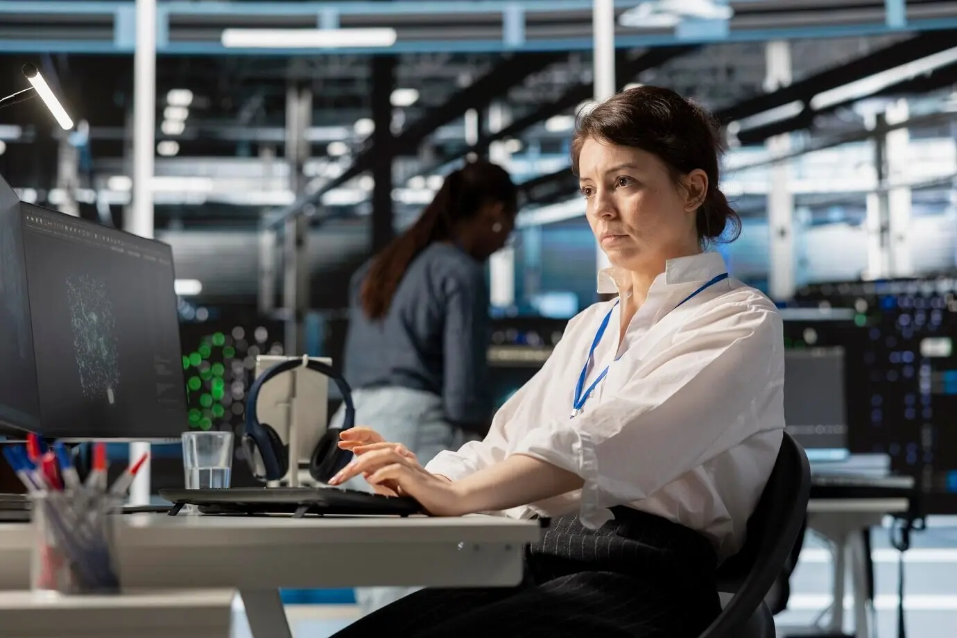 Специалист по компьютерным наукам в дата-центре использует ПК для обновления серверных технологий.